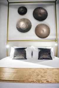 卡塔尼亚Scene Suites Apartments的一间卧室配有一张带床头板和枕头的床