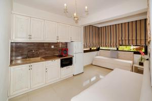 尼基季kassandrinos apartments apostolos的厨房配有白色橱柜和水槽