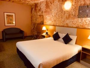 库伯佩迪沙漠卡文酒店的配有一张床和一把椅子的酒店客房