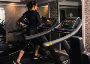 布罗德韦The Lygon Arms - an Iconic Luxury Hotel的一名在健身房跑步机上跑步的女人
