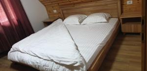 瓦勒博内Bujtinat e lugines Valbone的一张带白色床单和枕头的床