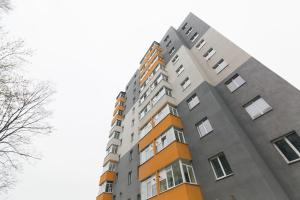 苏梅Luxury apart-hotel on Kharkovskaya New Building 6 floor的一座高大的公寓楼,拥有橙色和灰色