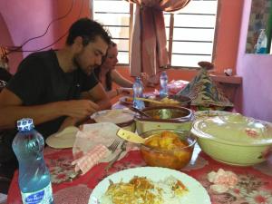 WasiniWasini Raha Snorkeling and Diving的坐在餐桌旁吃饭的男人和女人