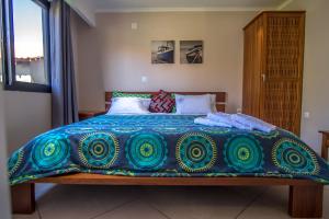 普拉伊拉多比莱尼Ossanzaia Bilene Lodge的床上有蓝色和绿色的毯子