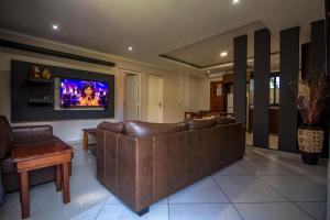 普拉伊拉多比莱尼Ossanzaia Bilene Lodge的客厅配有沙发和墙上的电视