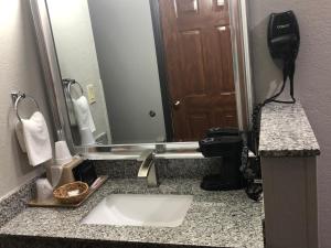 拉夫金德州勒夫套房酒店的一间带水槽和大镜子的浴室