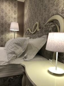 文尼察Hotel Boutique TOVMED的一间卧室配有一张带枕头和灯的床