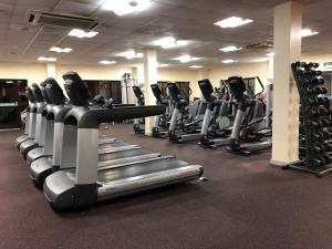 米尔顿凯恩斯National Badminton Centre Lodge & Health Club的健身房,配有一排跑步机和机器