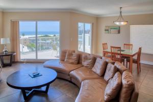 圣徒皮特海滩Crystal Palms Beach Resort的客厅配有棕色皮沙发和桌子