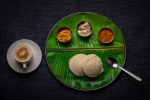 特里凡得琅Sri Udupi Hotel的含有不同食物和咖啡的绿盘