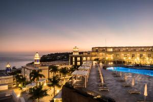 甘迪亚海滩Royal Palm Resort & Spa - Adults Only的享有带游泳池和大海的建筑景致