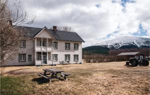 廷瑟Beautiful Home In Tynset With Kitchen的一座带野餐桌和雪覆盖的山房子