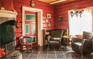 廷瑟Beautiful Home In Tynset With Kitchen的客厅设有红色的墙壁、椅子和壁炉