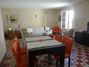 阿尔勒La Fleury的客厅配有桌子和橙色椅子