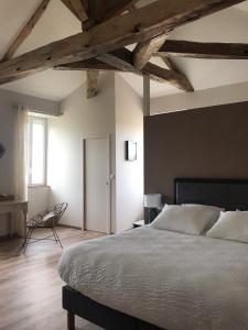 CabariotLa Clé du Puy的一间卧室配有一张大床和一把椅子