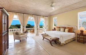 圣詹姆斯Royal Westmoreland Benjoli Breeze, Palm Ridge 10 by Island Villas的一间卧室设有一张床和一个海景阳台