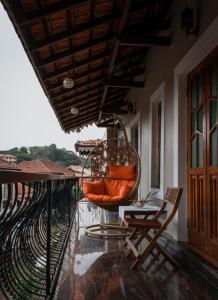 帕纳吉O Abrigo的阳台的门廊配有秋千和椅子