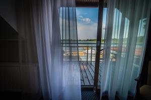 格鲁德柴兹Hotel Rudnik的阳台的窗户配有窗帘,享有风景。