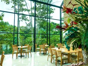 ParaísoSummit Rainforest Golf Resort & All Inclusive的餐厅设有桌椅和窗户。