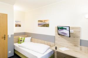 库克斯港Gästehaus Alexandra的一间设有床铺和墙上电视的房间