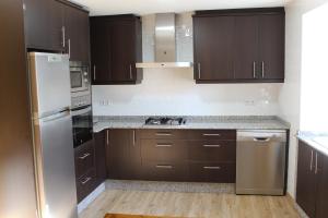 PiñeiroCasa Solveira的厨房配有棕色橱柜和不锈钢用具
