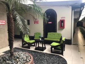 瓜亚基尔Hotel Imperial的大堂设有绿色椅子和棕榈树