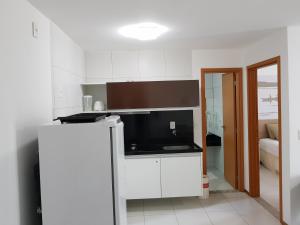 拉巴拉德纳圣米格尔Iloa Residence Resort - Barra de São Miguel的厨房配有白色橱柜和黑色台面