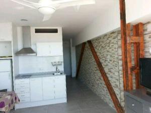 贝利雷瓜尔德Acogedor apartamento con vistas al mar.的厨房配有白色橱柜和砖墙