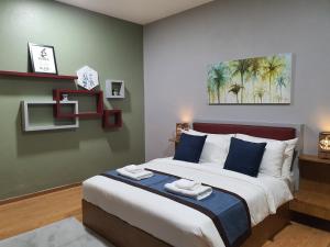 哥打巴鲁Assalam Hotel的一间卧室配有一张带蓝色枕头的大床