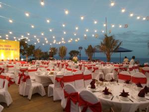 惹岛Ly Son Pearl Island Hotel & Resort的宴会厅配有白色桌子和红色弓