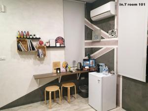 台南In.T 的厨房配有书桌、两把凳子和冰箱。