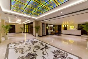 贾姆穆Lemon Tree Hotel Jammu的大堂设有彩色玻璃天花板