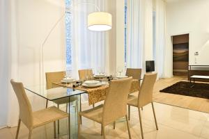 维也纳Central Luxury Apartment的一间设有玻璃桌和椅子的用餐室