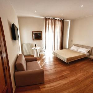 焦亚德尔科莱阿瑟肯多皮安诺住宿加早餐旅馆的一间卧室配有一张床、一张沙发和一把椅子