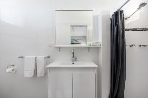 麦夸里港麦夸里港旅馆的白色的浴室设有水槽和淋浴。