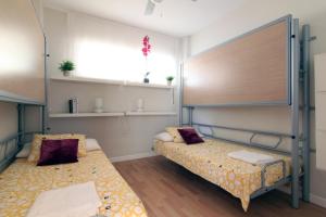 加的斯Apartamento Playa Victoria Cadiz的客房设有两张床和大窗户。