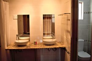 Divundu帝梵度旅馆的浴室设有2个水槽和2面镜子