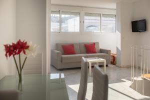 塞维利亚雷瑟法洛恩马里亚诺卡维亚公寓的带沙发和玻璃桌的客厅