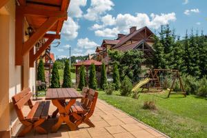 什恰夫尼察Apartamenty Tyrol的一个带桌椅的庭院和一个游乐场