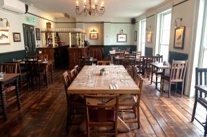 伦敦Admiral Hardy的用餐室配有木桌和椅子