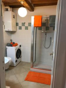 蒙特瓦尔基Appartamento Cilembrini的带淋浴和洗衣机的浴室