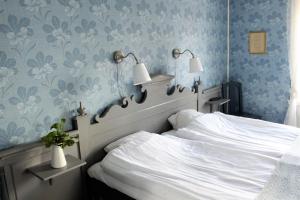 威廉敏娜威廉明娜教堂村STF酒店的卧室配有白色床和蓝色花卉壁纸