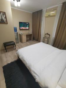 乌斯季卡缅诺戈尔斯克Deluxe SPA-Hotel的卧室配有一张白色大床和电视。