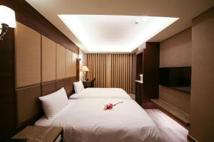 台南沐月二馆的酒店客房设有两张床和电视。