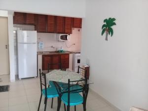 卡拉瓜塔图巴Ap na Avenida da Praia的厨房配有桌椅和白色冰箱。