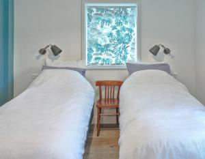 HarenB&B d'n Uilenhof Haren的配有椅子和窗户的客房内的两张床