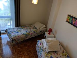 波尔图波尔图孟山多公寓的小房间设有两张床和窗户