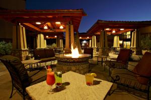 埃尔帕索埃尔帕索机场温德姆酒店的庭院设有2张桌子、饮料和火坑