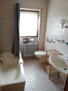 RötenbachGästehaus Rössle的带浴缸、卫生间和盥洗盆的浴室