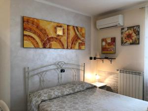 蓬泰代拉Da Donna Rosa的卧室配有一张床,墙上挂有绘画作品